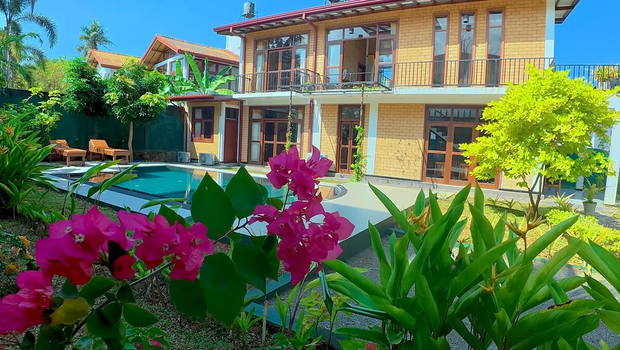 زهور استوائية والفيلا والمسبح خلفها — Syndeo Garden, هيكادوا